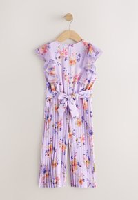 Combinaison sans manches lilas à motif floral, épaules volantées, jambes larges plissées et ceinture nouée à la taille, suspendue à un cintre en bois.