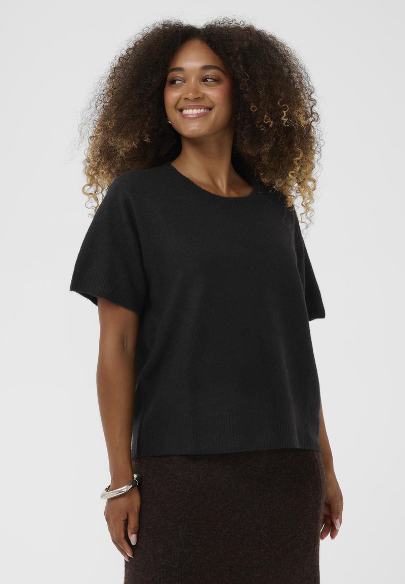 Black short-sleeved knit sweater with a round neckline and a relaxed fit, paired with a dark textured skirt. Soft fabric, casual design.
