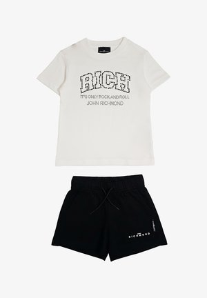 T-shirt bianca a maniche corte con la scritta "RICH" e testo, abbinata a pantaloncini neri con coulisse e logo "John Richmond".
