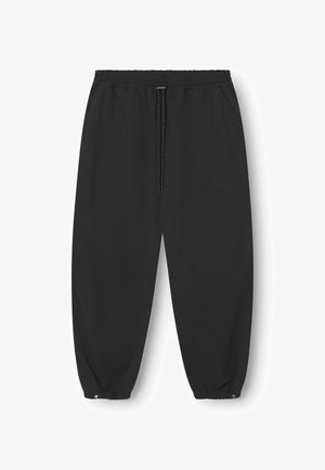 Černé kalhoty s elastickým pasem a šňůrkou. Mají zúžené nohavice s elastickými manžetami a bočními kapsami. Hladký, lehký materiál.