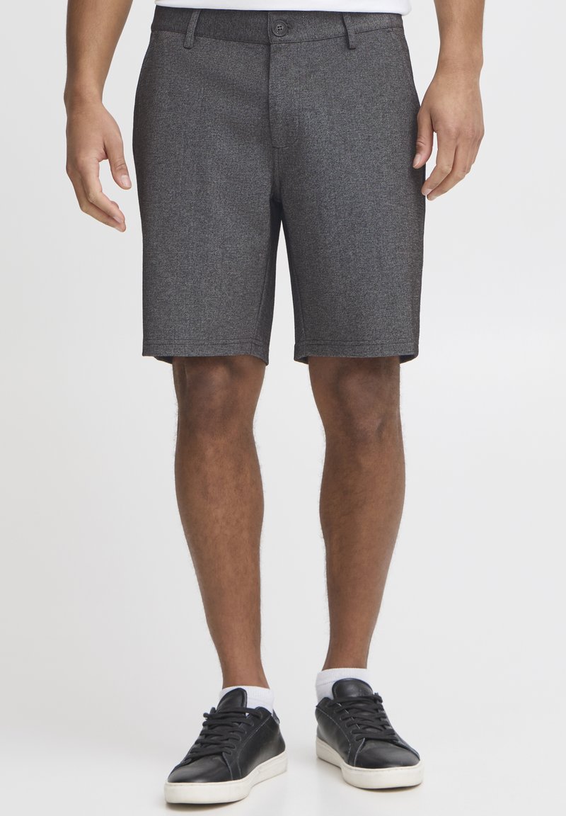 Szare teksturowane szorty chino o slim fit, z ulkowymi na pasek i kieszeniami z przodu, w połączeniu z czarnymi trampkami i białymi skarpetkami do kostek.