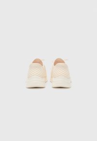 Beige Sport Schuhe mit einem strukturierten Mesh-Obermaterial und einer weichen Sohle. Verfügt über ein minimalistisches Design und einen kontrastierenden Akzent an der Ferse.