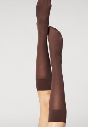 Bruna knästrumpor i halvgenomskinligt material med en solid, ribbad kant. Designen har en slät textur och en åtsittande form.
