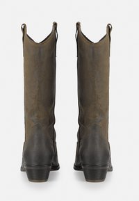 Botas altas de cuero marrón con un acabado suave, puntera afilada y detalles de costura. Cuentan con un tacón bajo tipo bloque y lengüetas de sujeción.