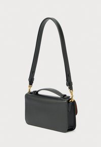 Črna usnjena torbica pravokotne oblike, s ploskim profilom in snemljivim trakom. Ima zgornji ročaj in poudarke iz zlato toniranega kovinskega okrasja.
