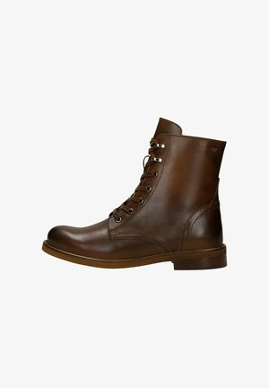 Bottines en cuir marron avec bout arrondi, conception à lacets, finition brillante et talon plat. Les détails notables incluent des œillets en argent et un logo.