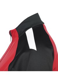 Giacca da ciclismo rossa e nera con colletto alto, dotata di una striscia riflettente bianca sul retro e un tessuto liscio e strutturato.