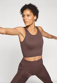 Brown ribbed sports crop top and matching high-waisted leggings, featuring a seamless design and stretchy fabric for comfort and movement.