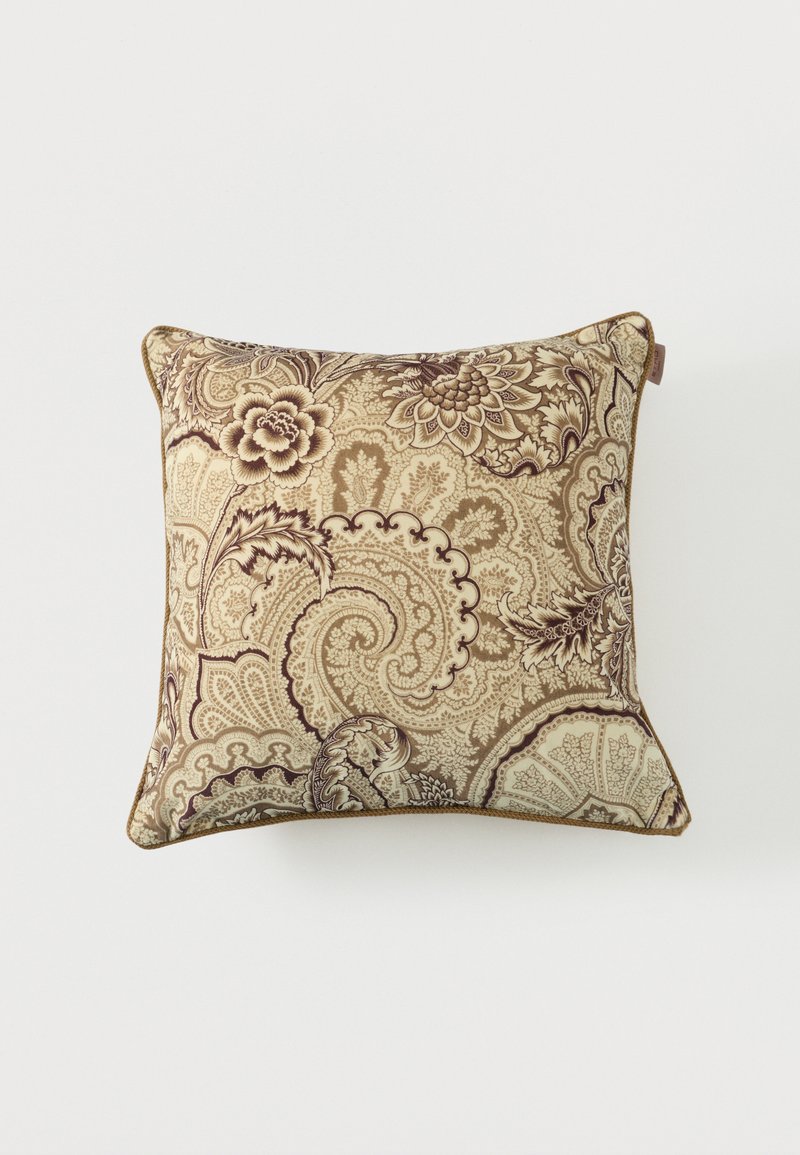 Coussin carré avec un motif complexe beige et marron de paisleys et de fleurs sur un fond blanc uni.