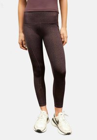 Högmidjade leggings i en mörk vinröd nyans med subtil svart leopardmönster, med elastiskt midjeband och en slät, jämn textur.