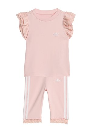 Completo rosa Adidas per bambino piccolo con maniche in pizzo arricciato, pantaloni con bordatura in pizzo, logo bianco sul petto e sui pantaloni, e strisce laterali bianche sui pantaloni.