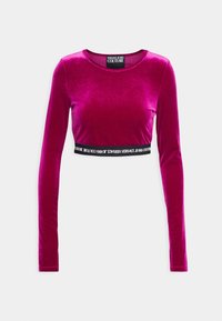 Fuksia pitkähihaine cropped-top pehmeästä samettikankaasta, jonka helmaan on ommeltu musta nauha, jossa on "Versace Jeans Couture" -logo.