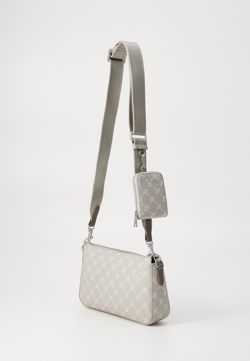 Beige Handtasche mit verstellbarem Tragegurt, verziert mit einem dezenten Blattmuster. Inklusive einer kleinen abnehmbaren Reißverschlusstasche. Glatte Textur.
