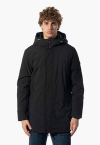 Parka nera con cappuccio, dotata di zip frontale, due tasche laterali e taglio dritto. Realizzata in materiale liscio e resistente all'acqua.