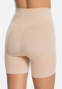 Beige shapewear shorts met een hoge taille, gemaakt van een gladde, rekbare stof. Heeft een naadloos ontwerp en een lengte tot halverwege de dijen.