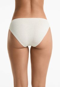 Ljusbeige bomullstrosa med en mjuk textur, medelhög midja och minimala sömnadsdetaljer. Enkelt och sömlöst design.
