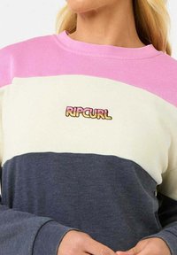 Felpa color block con un design in rosa, crema e grigio scuro. Logo "RIPCURL" ricamato sul petto. Tessuto morbido, colletto girocollo, maniche lunghe.