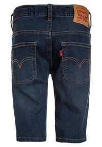 Pantalones cortos de mezclilla azul oscuro con un corte recto, que presentan dos bolsillos traseros adornados con costuras amarillas y una etiqueta de marca de cuero.