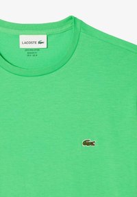 Zielony t-shirt z Pima bawełny, z okrągłym dekoltem, o regularnym kroju i haftowanym logo Lacoste na piersi. Gładka struktura, prosty design.