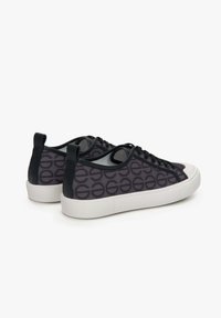Zwarte sneakers met een reliëfpatroon, witte rubberen zool en zwarte accenten; voorzien van vetersluiting en een trekhaak achterop.