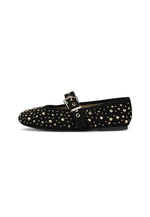 Zapato plano negro con tachuelas doradas por toda la superficie y una correa negra con una hebilla dorada en la parte superior.