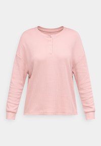 Långärmad, ljusrosa henley-topp med texturerat tyg, rund halsringning och tre knappdetaljer vid kragen. Avslappnad passform.