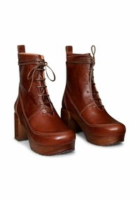 Bruine leren enkellaarsjes met een ronde neus, dikke blokhak en vetersluiting, met contrasterende stiksels en een gladde textuur.