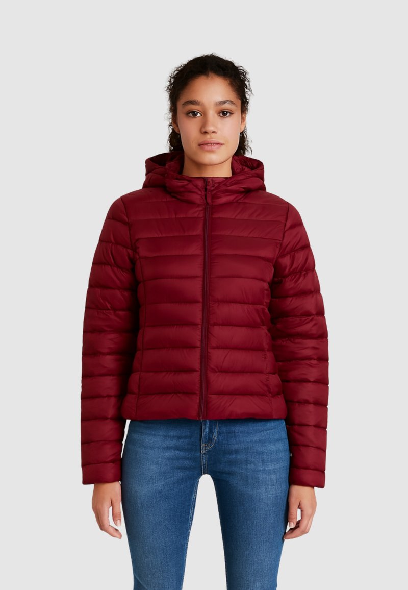 Bordo nafukovacia bunda so zúženým strihom, prešívaná textura, predný zips a kapucňa. V kombinácii s modrými džínami.