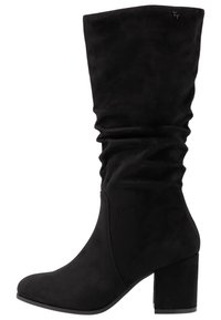 Svarta knälånga stövlar i mjuk mocka, med en slouchad design, rund tå och en kraftig klack för extra stabilitet.