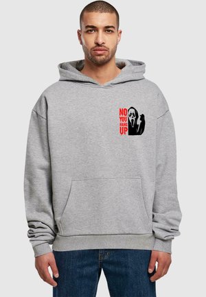 Grauer Hoodie mit einer vorderen Kängurutasche, mit einem grafischen Druck: eine Maske und der Text "NEIN, DU LEGEN AB" in Rot. Weicher, dicker Stoff.