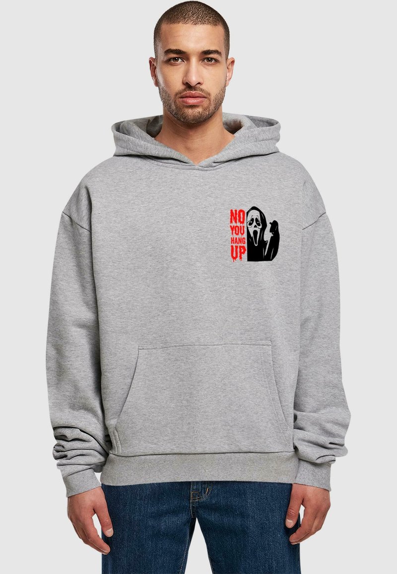 Grå hoodie med en frontlomme og grafisk tryk: en maske og tekst med "NEJ, DU LÆGGER PÅ" i rød. Blødt, tykt stof.