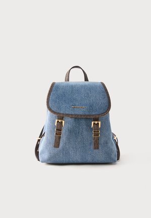 Niebieski plecak z denimu z brązowymi wykończeniami, złotymi klamrami, górnym uchwytem i przednią klapą z logo Michael Kors, na białym tle.