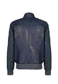 Chaqueta azul oscura con cuerpo de cuero y mangas de nailon, puños y dobladillo acanalados, y una etiqueta de marca rectangular en el cuello.
