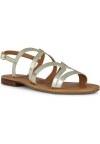 Sandalia metálica dorada con múltiples correas cruzadas, hebilla ajustable en el tobillo y suela plana marrón. Textura suave con un diseño minimalista.