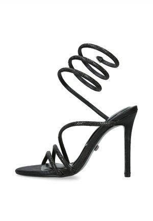 Czarna sandałka na wysokim obcasie z wieloma cienkimi paskami, w tym trzema z przodu stopy oraz oplatającym kostkę paskiem skręconym w spiralę.