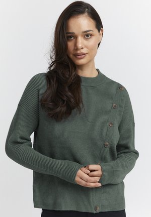 Pull en maille côtelée vert avec un col rond et une fermeture à boutons sur le côté gauche ; il possède des manches longues et une coupe ample.