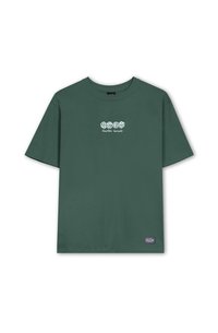 Green cotton t-shirt with short sleeves, round neck, and front graphic text "Karaoke Society." Features a small brand label on the hem.