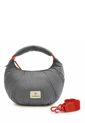 Gray ribbed fabric handbag with short padded handle, rectangular front label, and detachable red strap with clasps beside it.