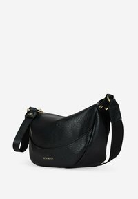 Bolso de hombro de cuero negro con forma curva, superficie texturizada, detalles en hardware dorado y una correa ajustable. Logo de la marca visible.