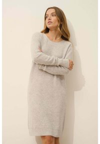 Abito a maglia grigio chiaro a coste, maniche lunghe, collo rotondo, di lunghezza media, morbido al tatto, aderente in vita, vestibilità rilassata, design minimalista.