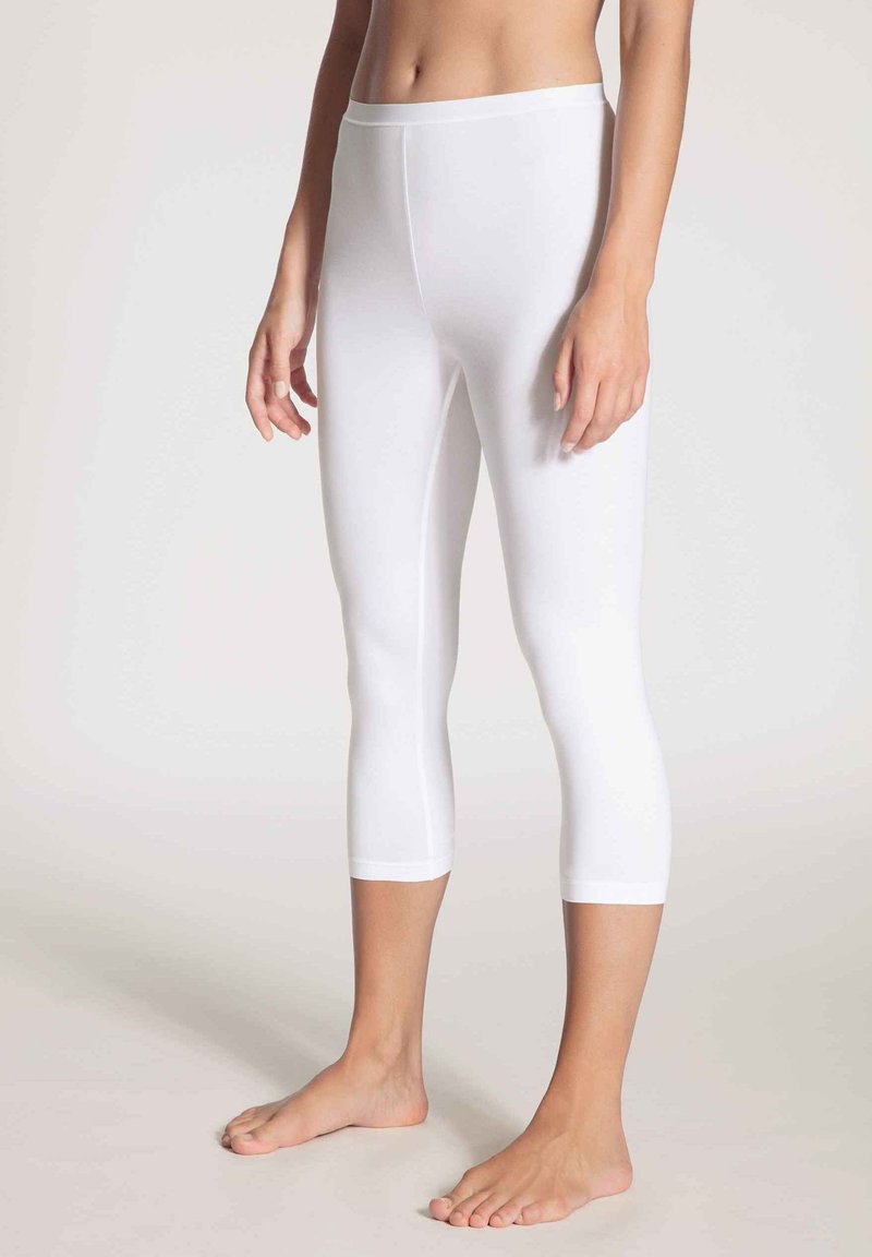 Witte capri-legging gemaakt van een gladde, rekbare stof met een aansluitend ontwerp. Heeft een brede tailleband en eindigt net onder het scheenbeen.