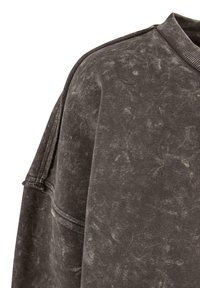 Mørkegrå sweatshirt med en lett slitt tekstur, ribbet halslinning og stikking detaljer på skulderen og ermet.