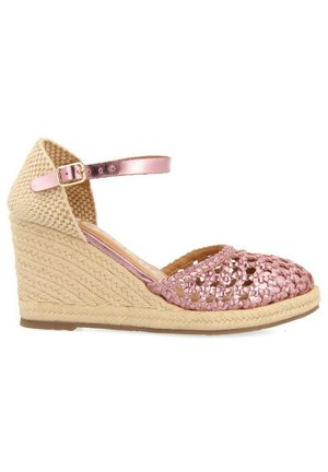 Espadrille de cuña con una plantilla de yute beige, parte superior metálica rosa y correa ajustable rosa en el tobillo. Cuenta con una base de plataforma de yute texturizado.