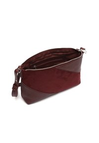 Bordo kožni i suknirani clutch s zatvaračem na munje, s glatkom teksturom i kutnim dizajnom. Unutrašnjost uključuje džepove sa zatvaračem i džepove za slobodne predmete.