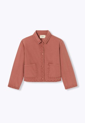 Veste courte couleur rouille avec manches longues, boutons à l'avant, deux grandes poches avant et un col classique.