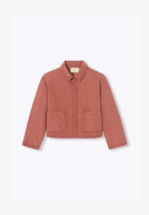 Veste courte couleur rouille avec manches longues, boutons à l'avant, deux grandes poches avant et un col classique.