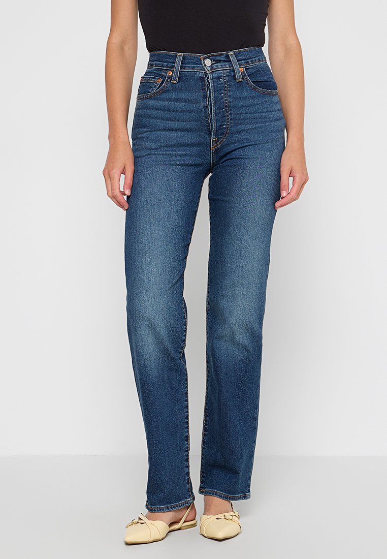 Jeans in denim blu a vita alta con taglio dritto, caratterizzati da cuciture visibili, tasche frontali e chiusura con bottoni classica.