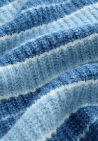 Gestrickter Stoff mit abwechselnden blauen und hellblauen Streifen sowie einer weichen, strukturierten Webart, die ein flauschiges und gemütliches Erscheinungsbild betont.