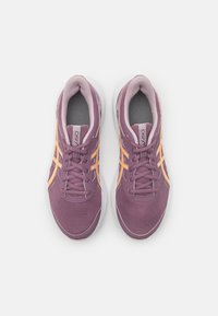 Chaussures de sport violettes avec tige en mesh, accents orange, bout rond et semelle rembourrée. Comprend un design à lacets et un col rembourré pour le confort.