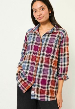 Plaid button-up shirt in multicolored hues of purple, blue, orange, and black; features a classic collar and rolled-up sleeves.